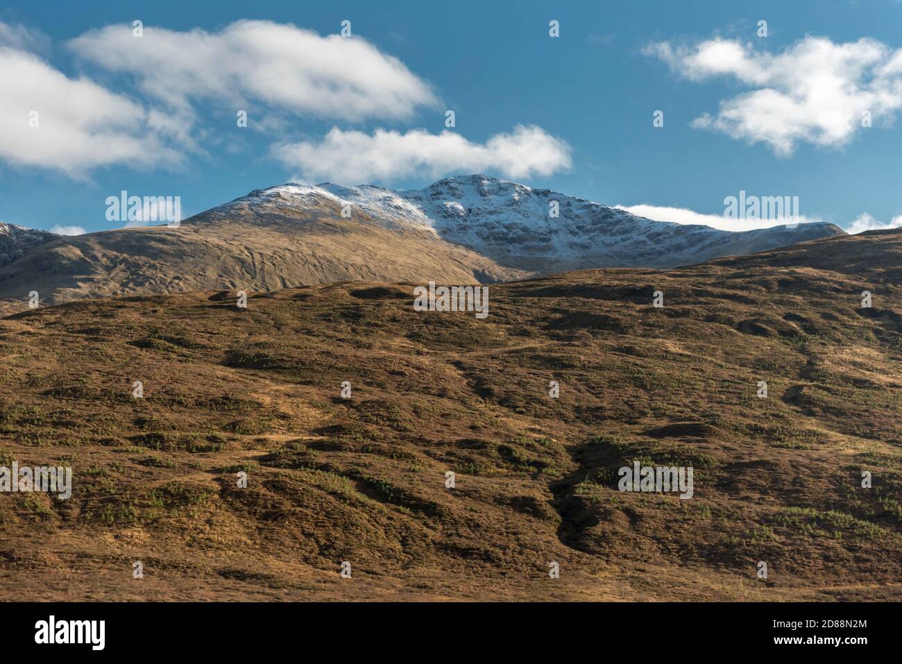 Snow peaked mountains with blue sky and white clouds in typical scottish highlands,United Kingdom. Stock Photo