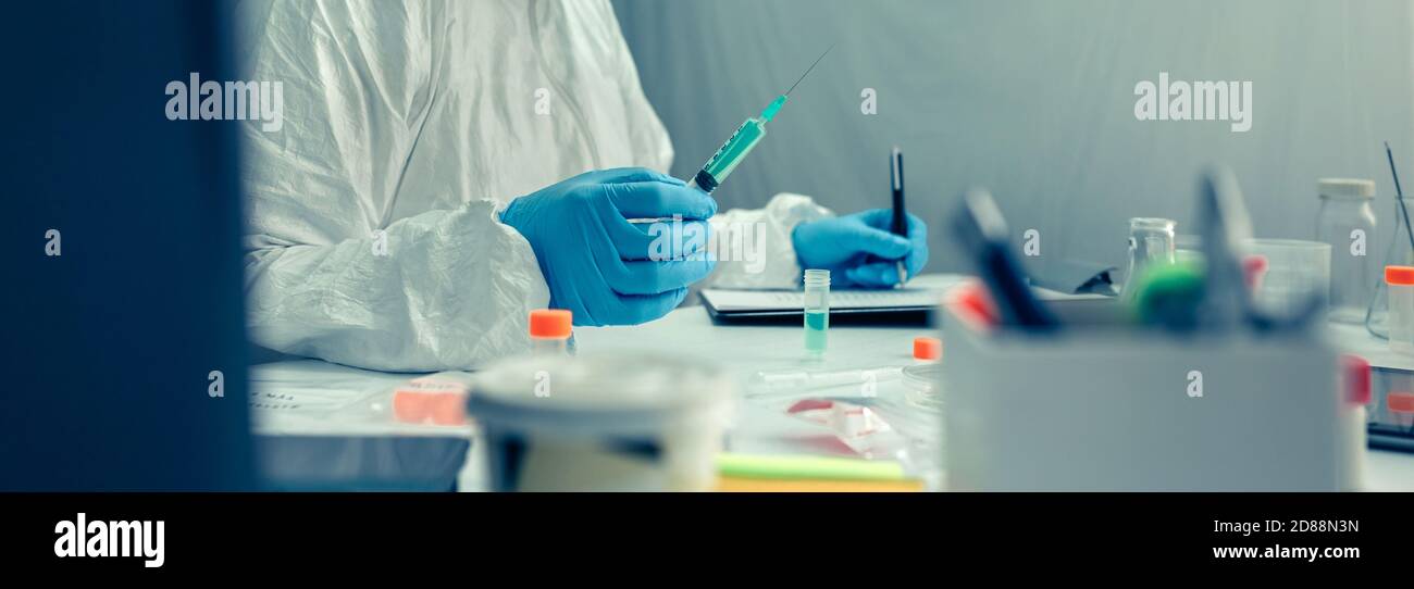 Scientist with protection suit investigating a vaccine in the laboratory Stock Photo