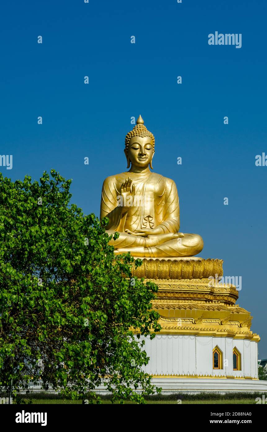 Golden statue of sitting Buddha in Shrawasti,India, in blue sky back ground. Stock Photo