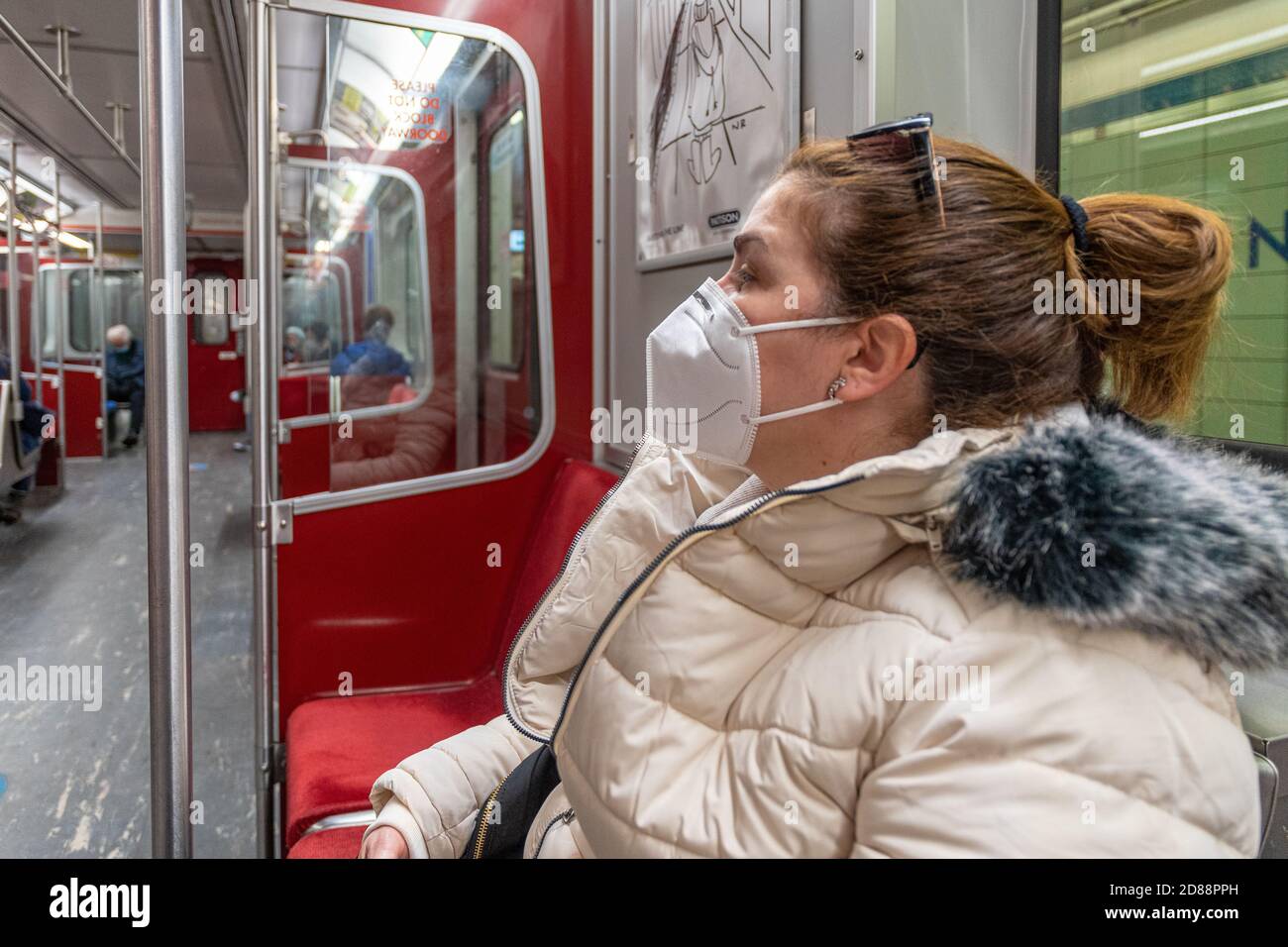 People wearing protective face masks while riding the TTC. Masks are