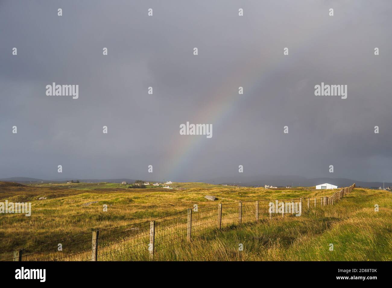 Dark skies and colourful rainbow over the hills of South Uist, Outer Hebrides, Scotland Stock Photo