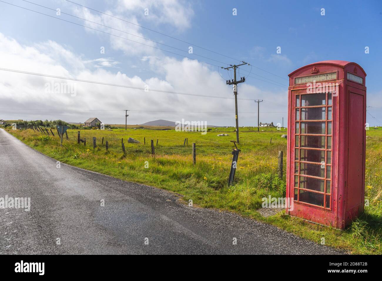 Red telephone box and crofters houses at North Uist, Outer Hebrides, Scotland Stock Photo