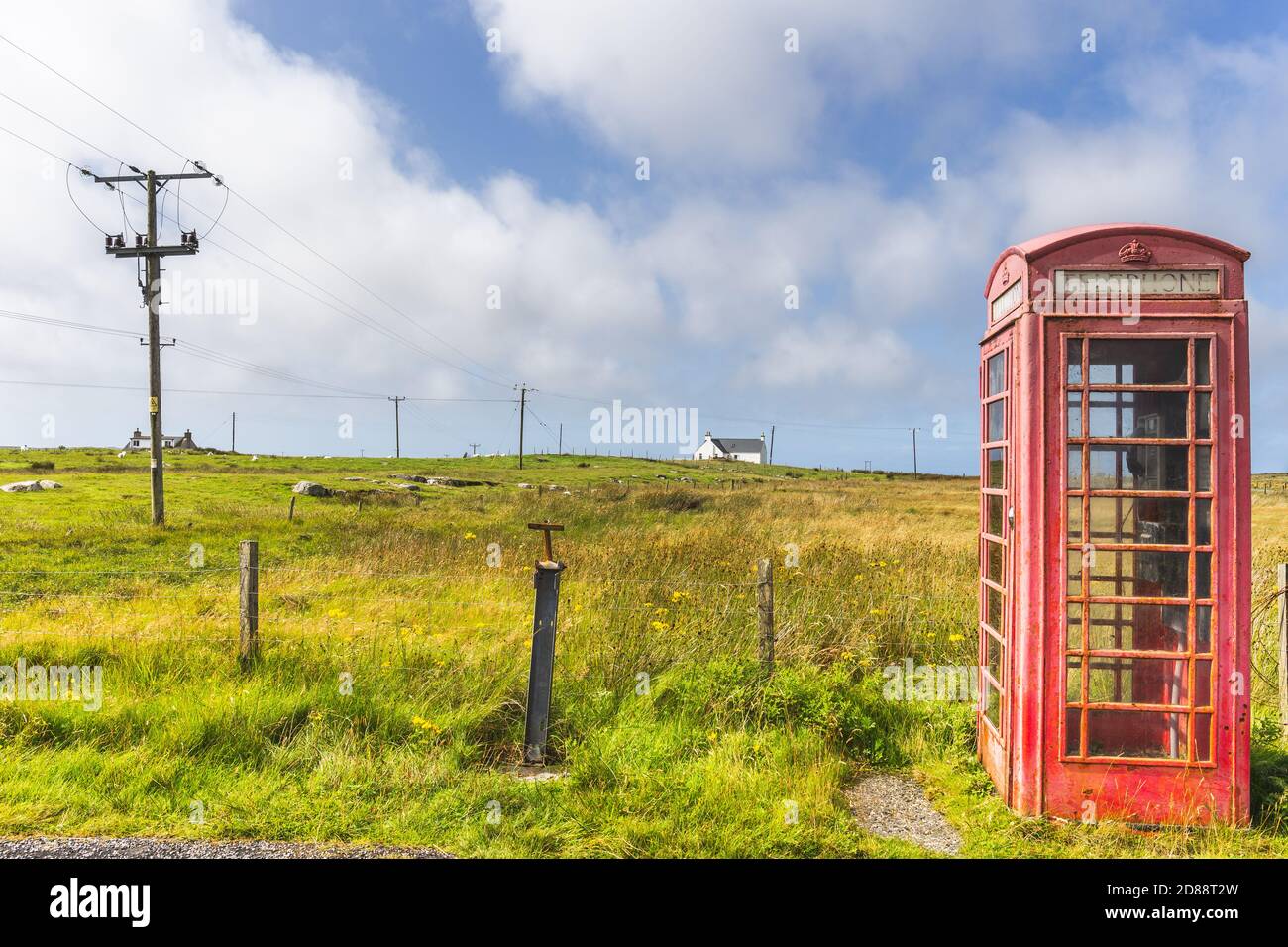 Red telephone box and crofters houses at North Uist, Outer Hebrides, Scotland Stock Photo