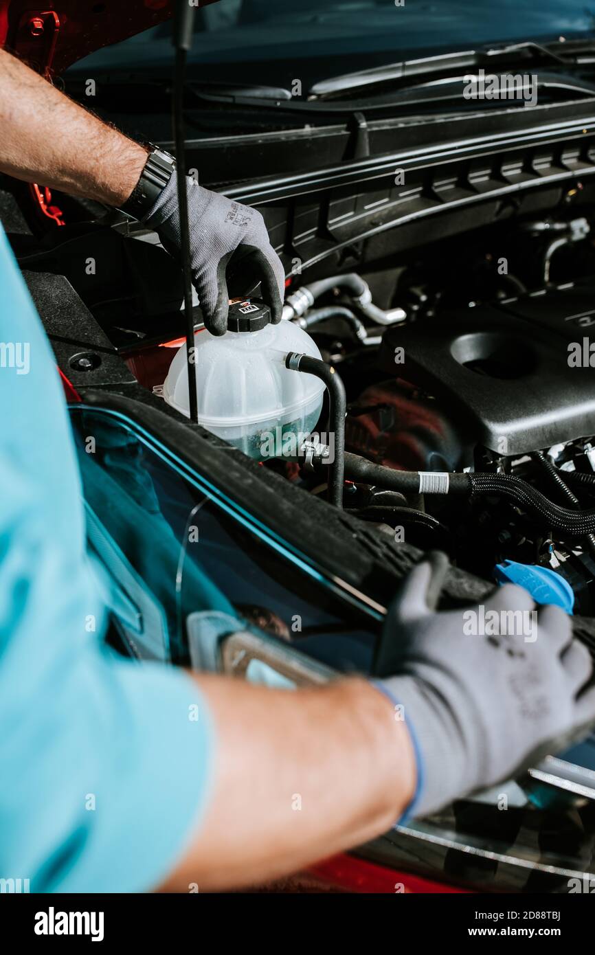 Mechanic examinates the cars technical conditions. Exterior view of a new car Stock Photo