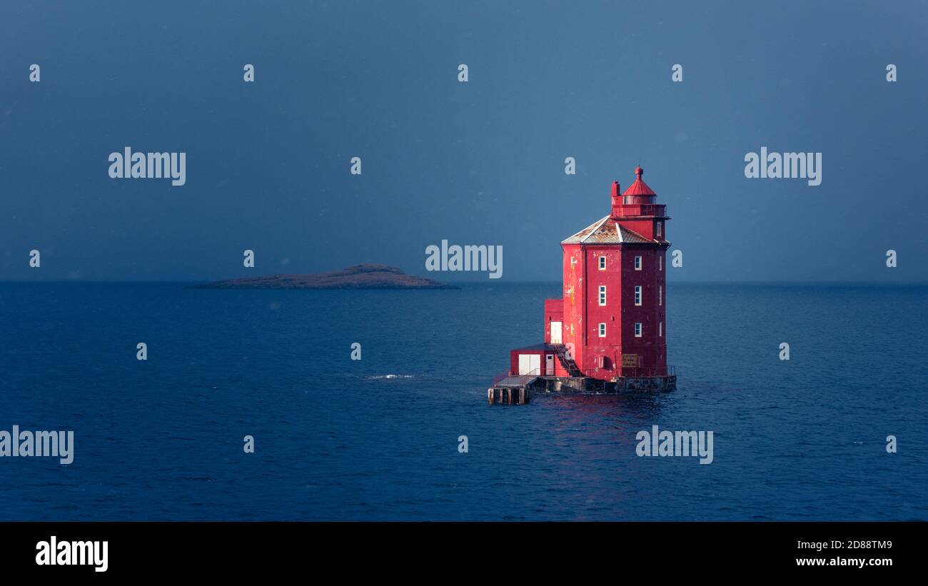 Famous red lighthouse  Kjeungskjær in the middle of the ocean near the Norwegian coast in snow storm Stock Photo