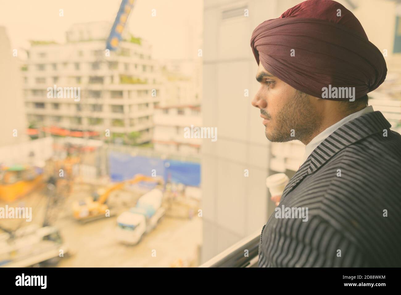 Young handsome Indian Sikh businessman wearing turban while exploring the city Stock Photo