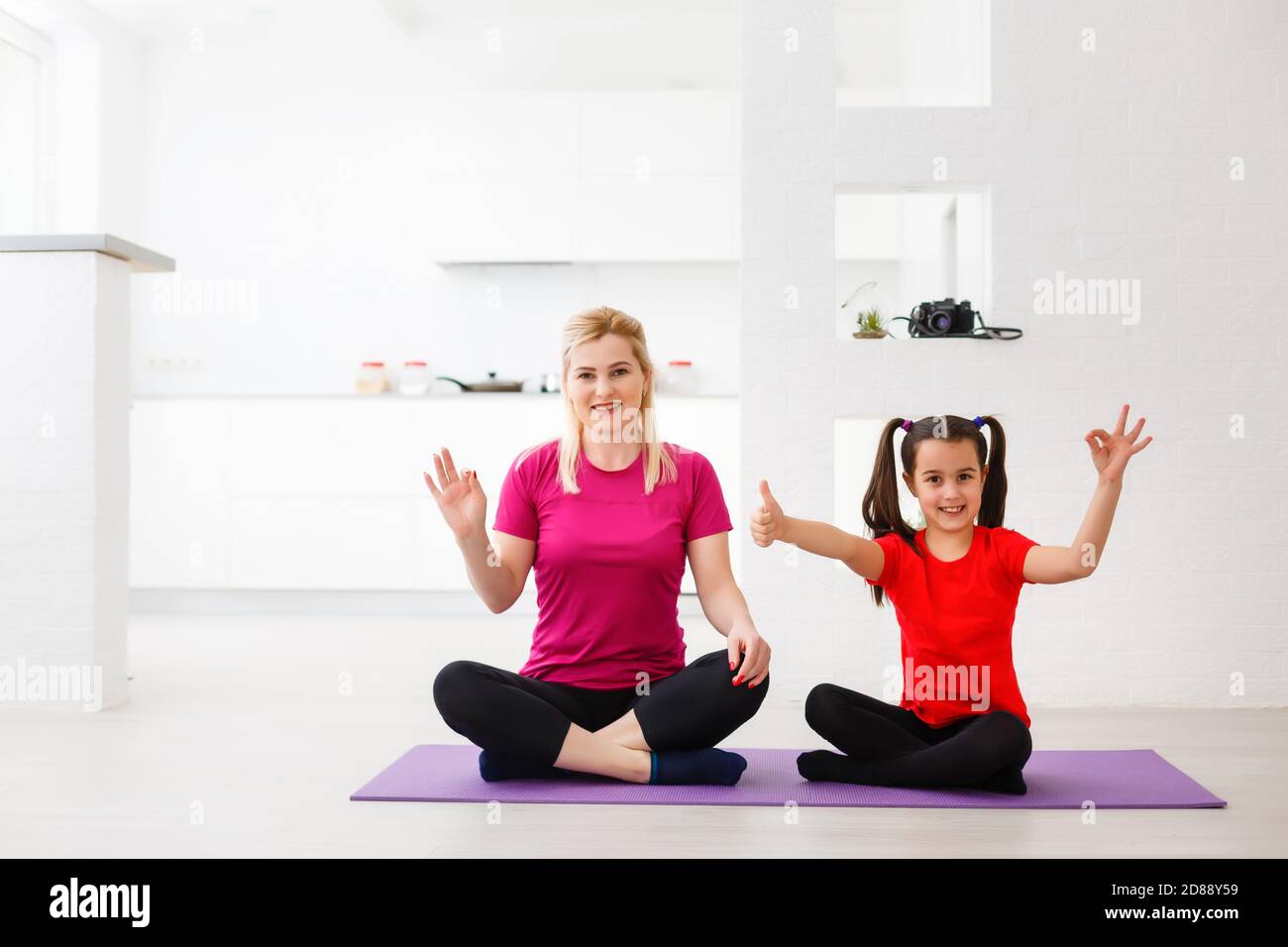 Mother and daughter doing yoga exercises on mat at home Stock Photo - Alamy