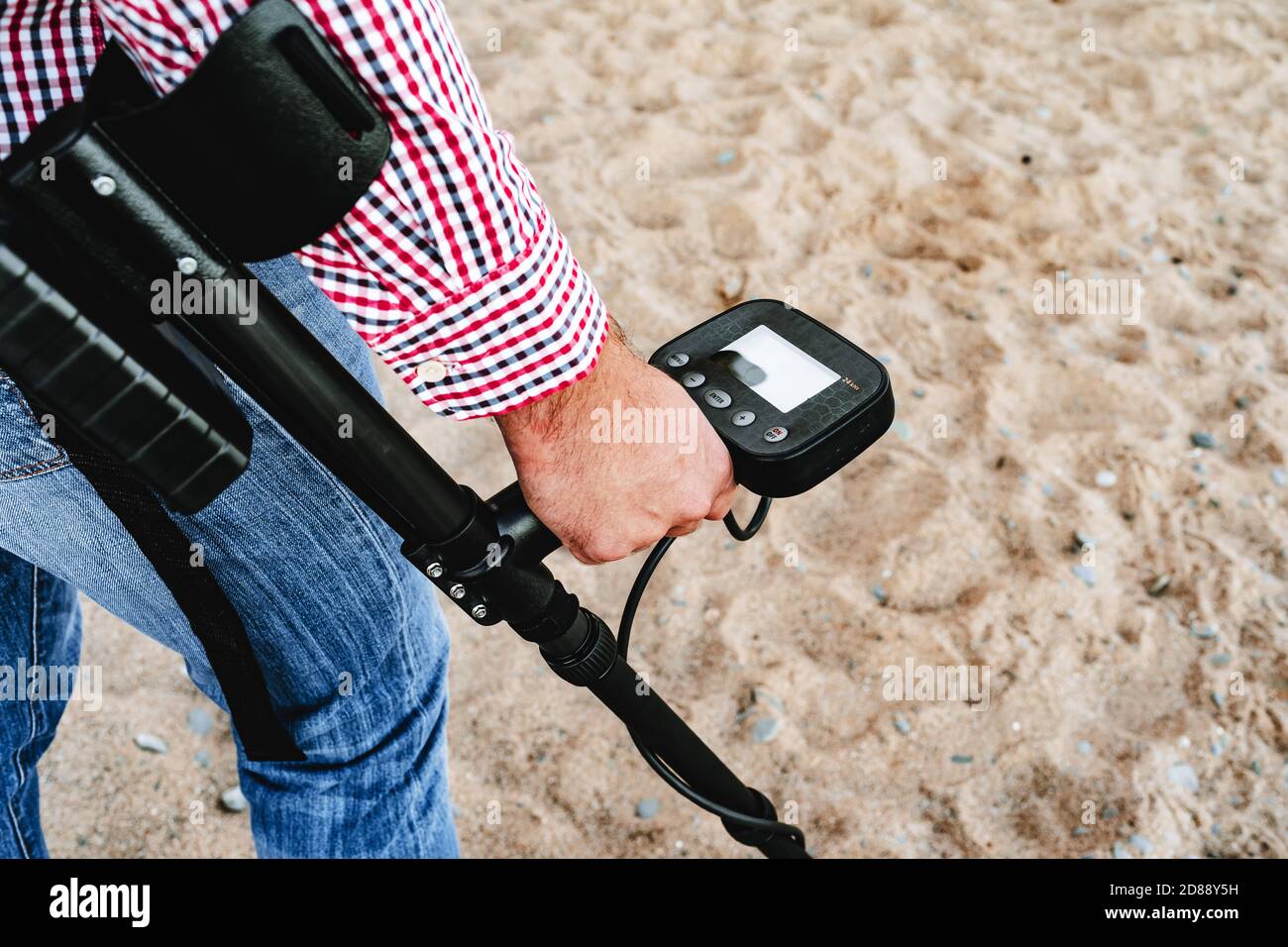 Male hand holding metal detector device above the ground Stock Photo ...