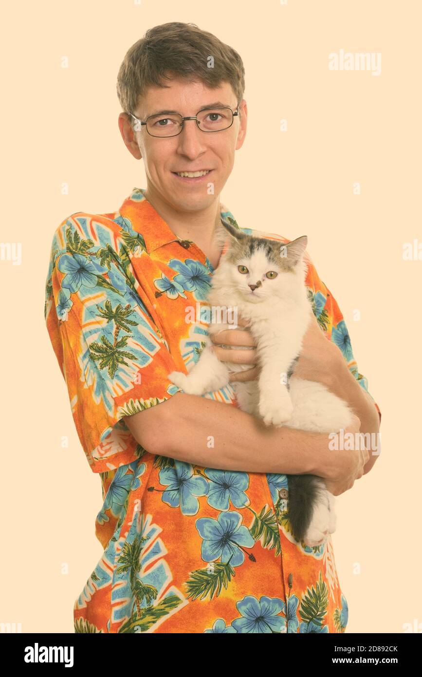 Studio shot of happy man smiling while holding cute cat Stock Photo