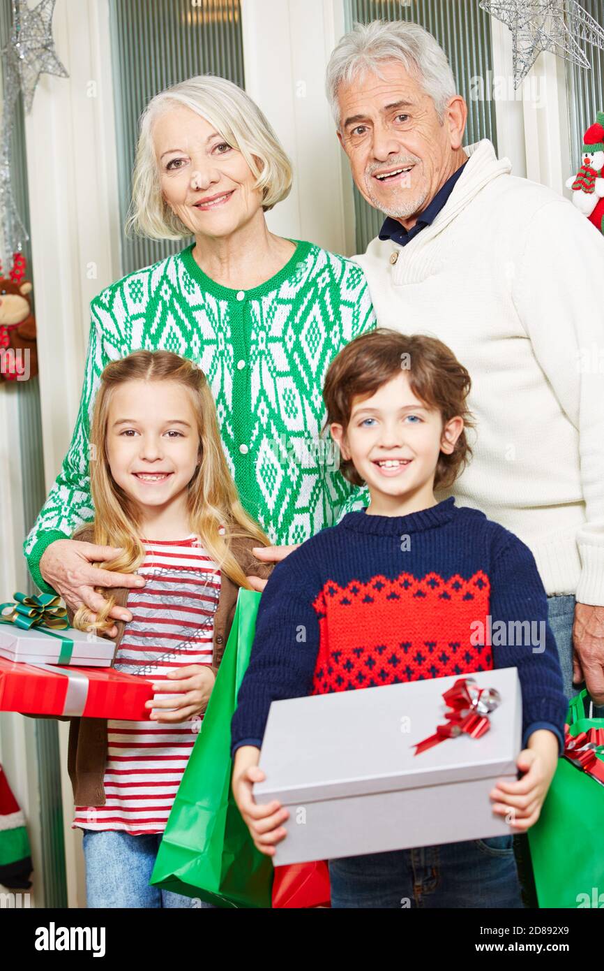 Happy grandparents with their grandchildren at Christmas with gifts