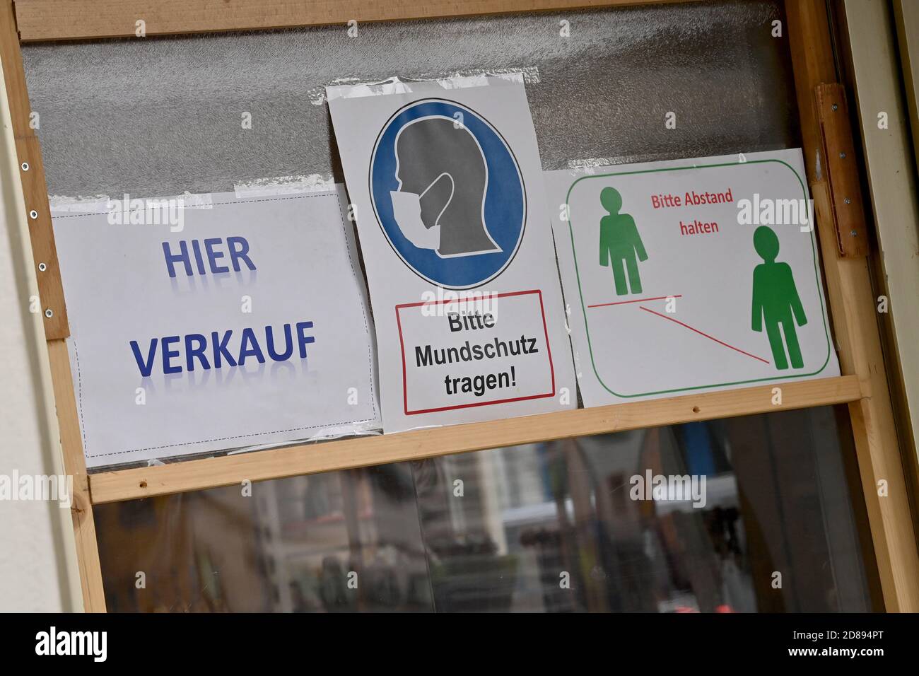 Rosenheim, Germany. 28th Oct, 2020. Signs with the inscription 'Hier Verkauf', 'Bitte Mundschutz tragen' and 'Bitte Abstand halten' hang on the door of a shop in the city centre. Credit: Peter Kneffel/dpa/Alamy Live News Stock Photo