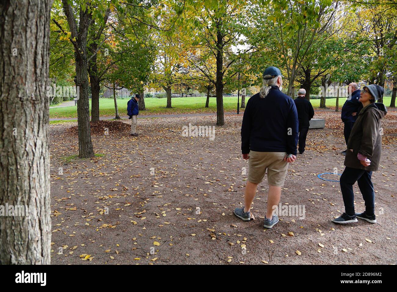 Vauxhall, London, UK. 28 Oct, 2020. UK Weather: Chilly but sunny with cloudy intervals and blustery winds. People enjoying the sunshine walking or running at the Vauxhall pleasure gardens. A group of people playing pétanque. Photo Credit: Paul Lawrenson-PAL Media/Alamy Live News Stock Photo