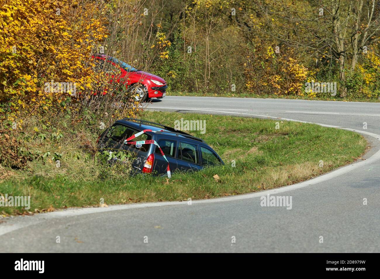 The car in the ditch by the road after the traffic accident. Abandoned and waiting for tow. Stock Photo