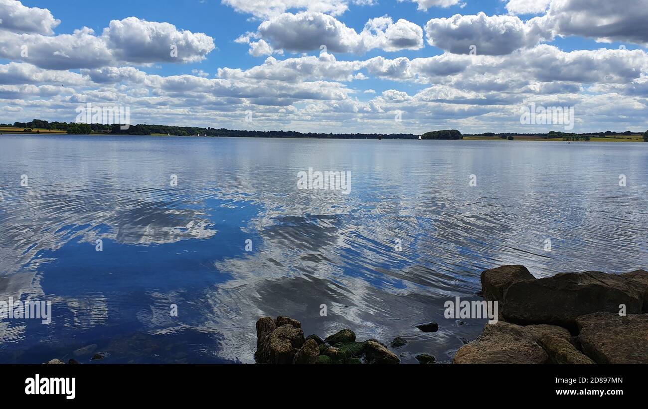 Mesmerizing view of a blue sky with fluffy clouds reflected in a lake ...