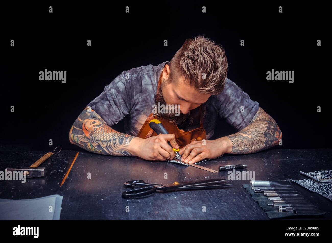 Leather Worker wording with leather goods at workplace Stock Photo