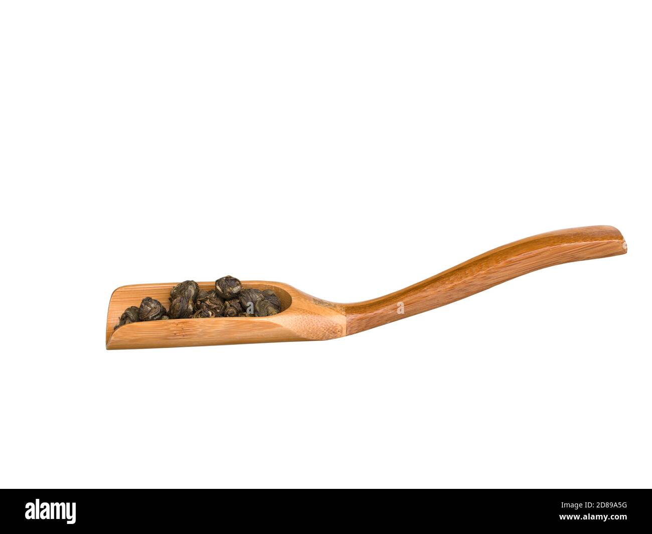 Wooden scoop with dry green tea leaves isolated on white background