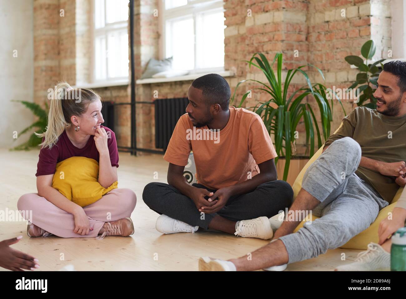 Group of young dancers sitting on the floor and resting after sports training in health club Stock Photo
