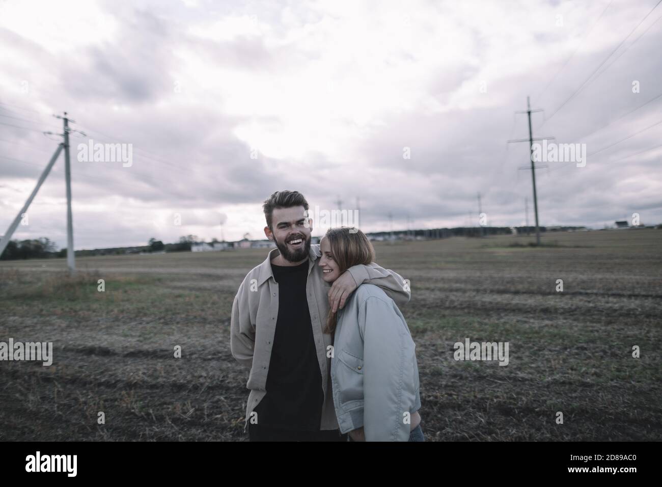a couple in love walks in an open soybean field in the evening in cloudy weather Stock Photo