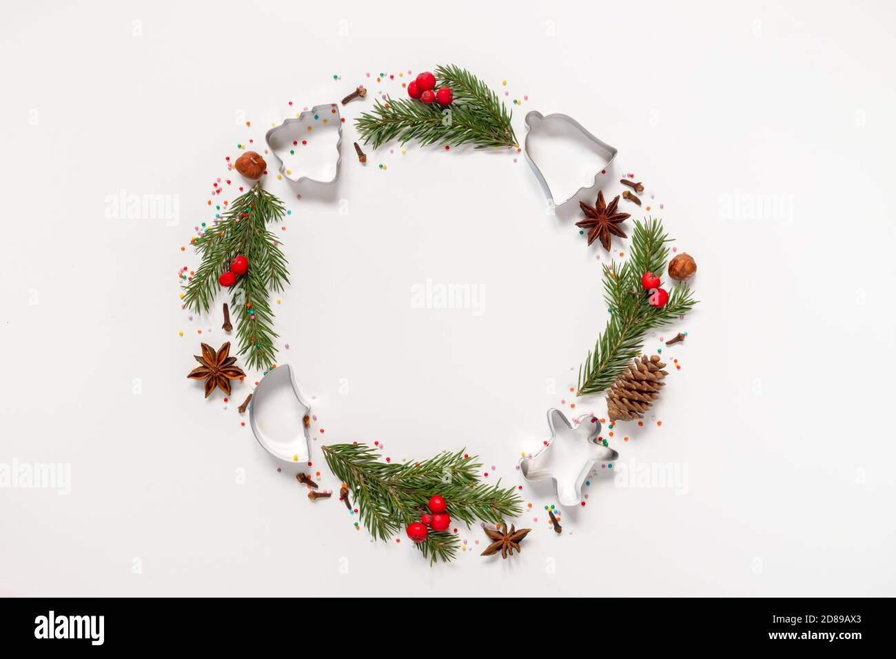 Christmas wreath made from molds for cookies, spices and a Christmas tree on a white background with copy space Stock Photo