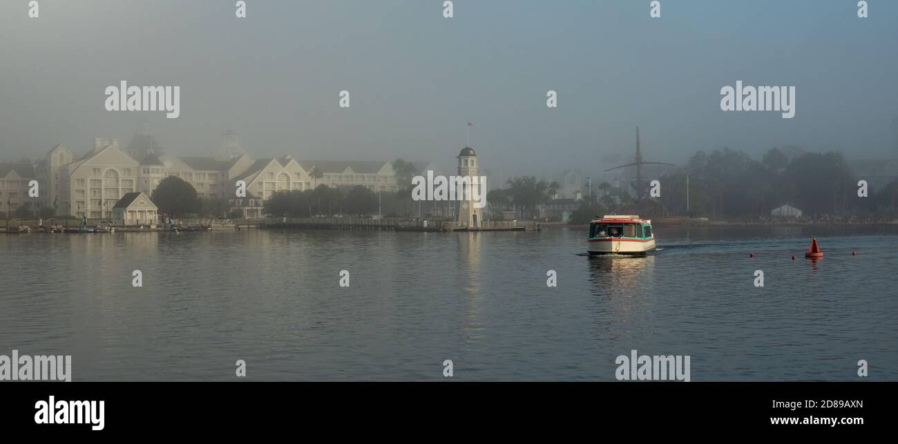 A Friendship Boat ferries passengers across the lake from Disney's Yacht Club Resort, Florida in an early morning mist Stock Photo
