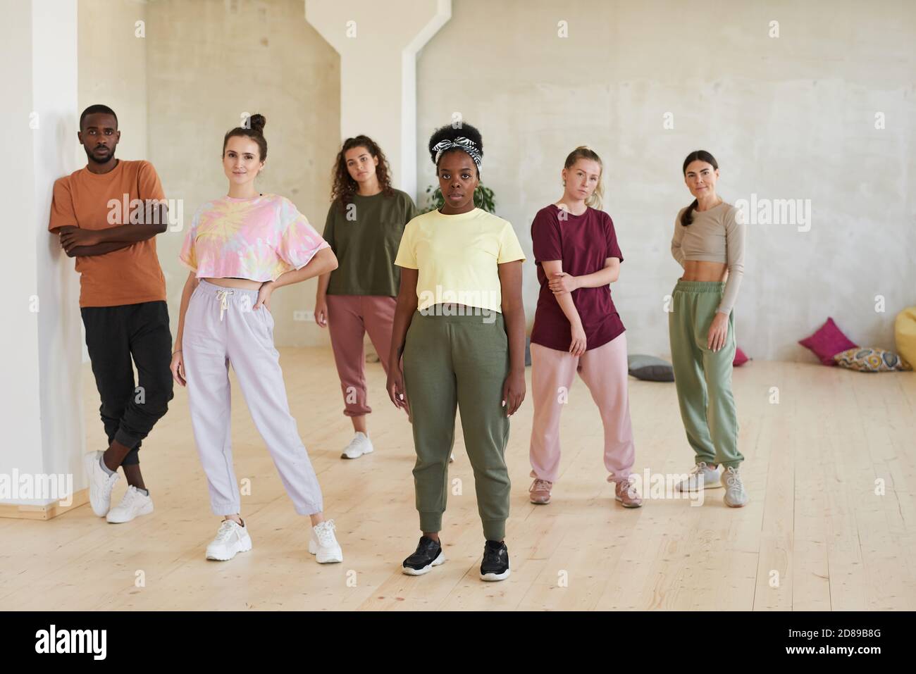 Portrait of team of young dancers looking at camera while standing in dance studio Stock Photo