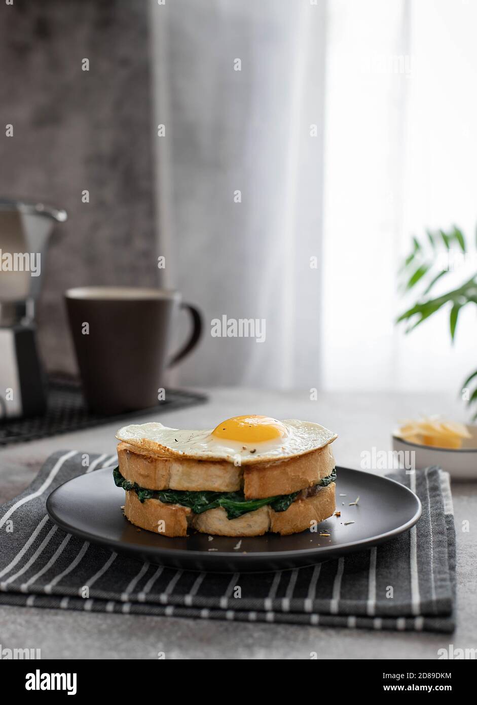 https://c8.alamy.com/comp/2D89DKM/tasty-healthy-sandwich-with-egg-spinach-and-cheese-on-a-dark-plate-coffee-maker-and-cup-with-coffee-2D89DKM.jpg
