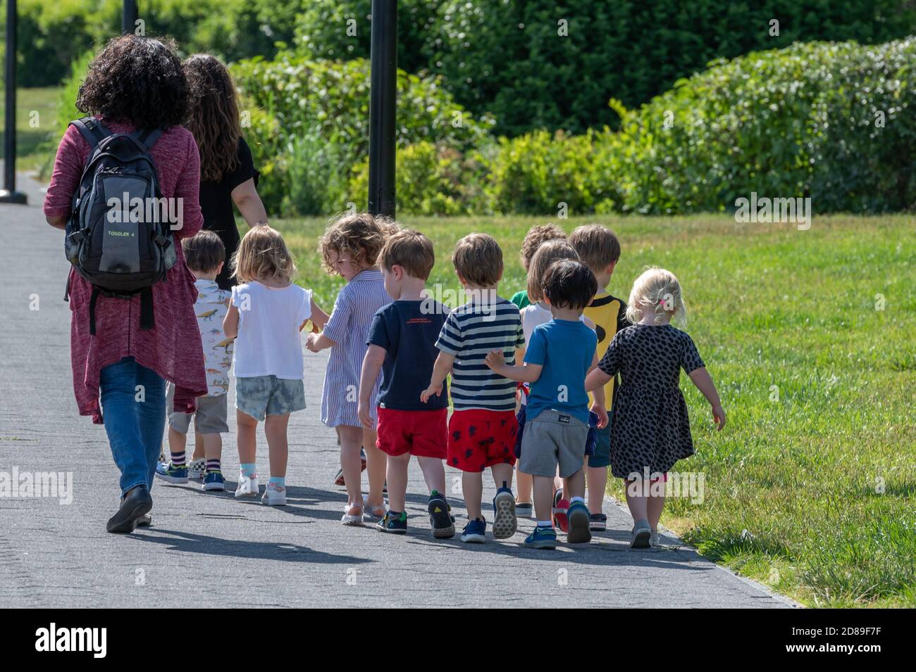 A line of kindergarten children following their teachers through Georgetown Waterfront Park in Washington DC Stock Photo