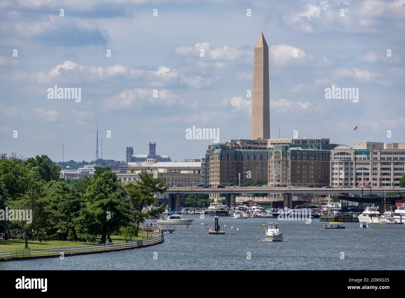 The Washington Monument looms over the Mandarin Oriental Hotel and Washington Channel, with the National  Cathedral in the distance. Stock Photo