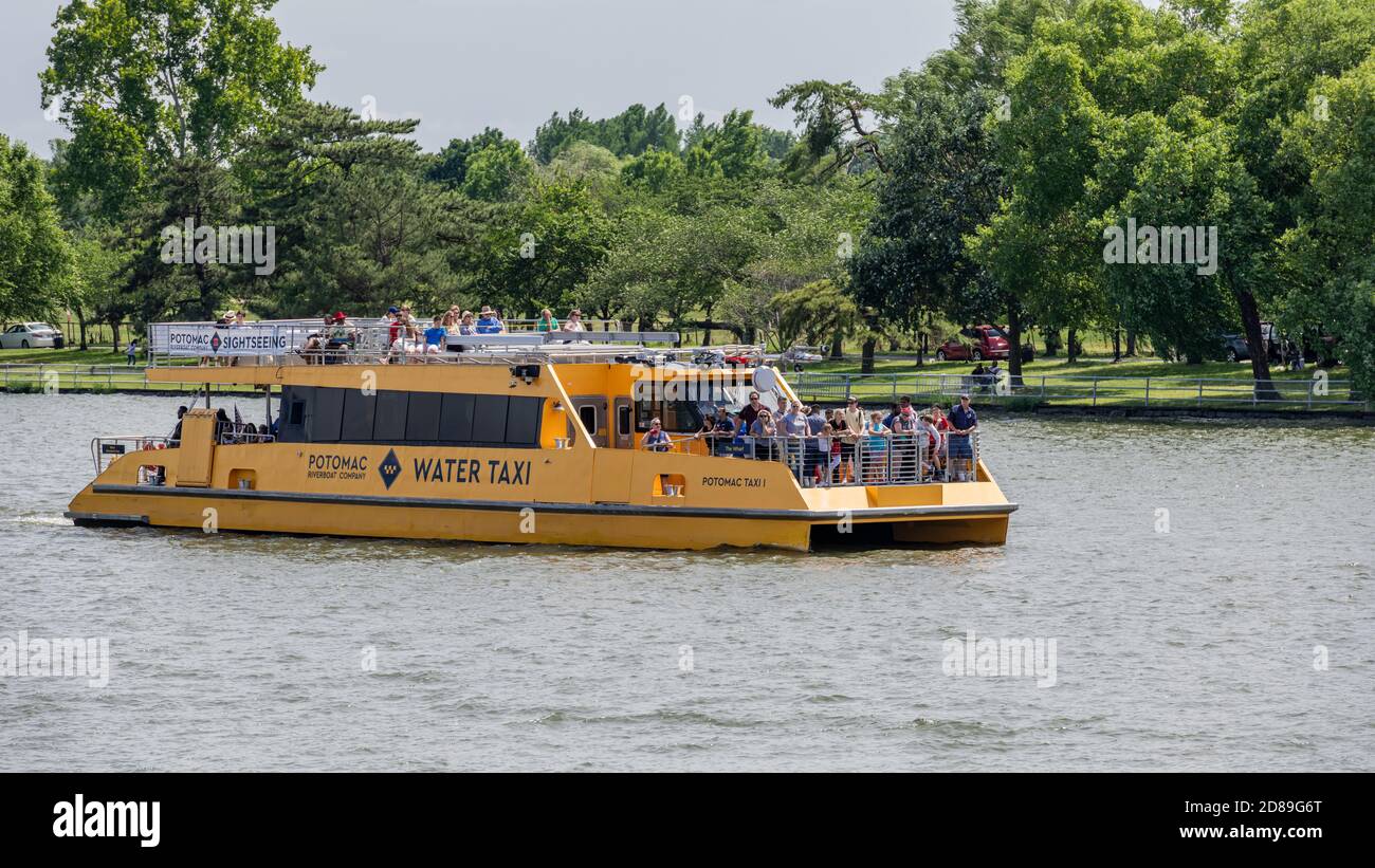 Tourists enjoying the early June sunshine crowd the bow of a Potomac River taxi en route to the Wharf in Washington, DC. Stock Photo