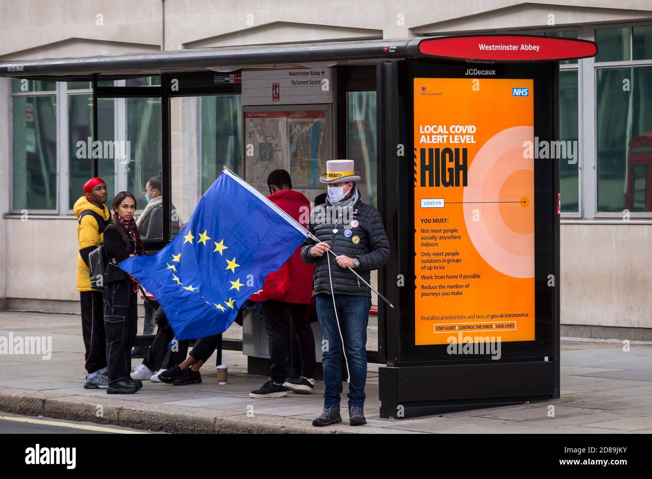 London, UK.  28 October 2020.  Steve Bray, an anti-Brexit protester from SODEM next to a Covid-19 alert related sign at a bus stop outside the Department for Business, Energy & Industrial Strategy in Westminster.  Michel Barnier, the European Commission's Head of Task Force for Relations with the United Kingdom, is attending meetings inside.  Credit: Stephen Chung / Alamy Live News Stock Photo