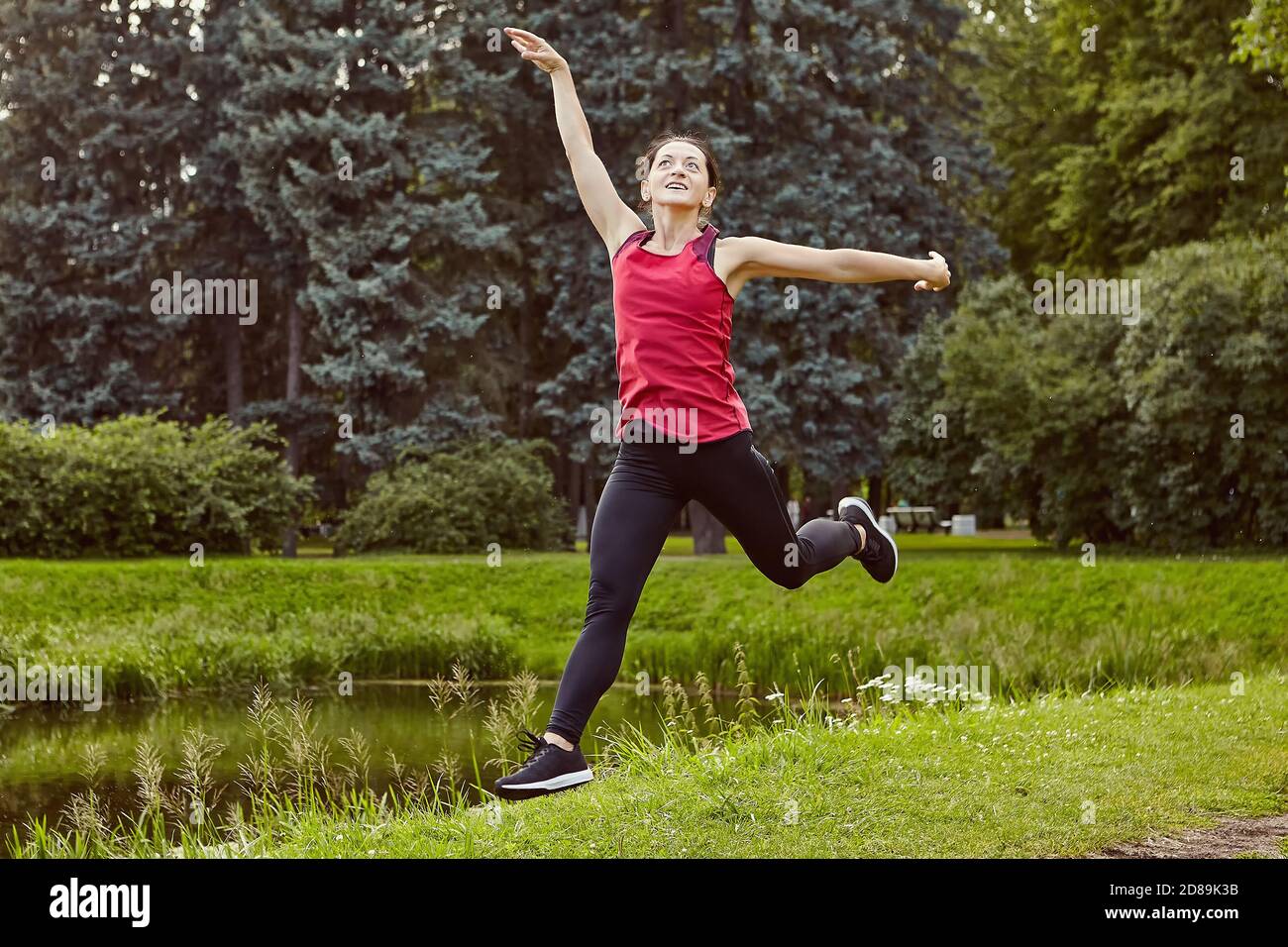 Female makes physical exercises on open air. Stock Photo