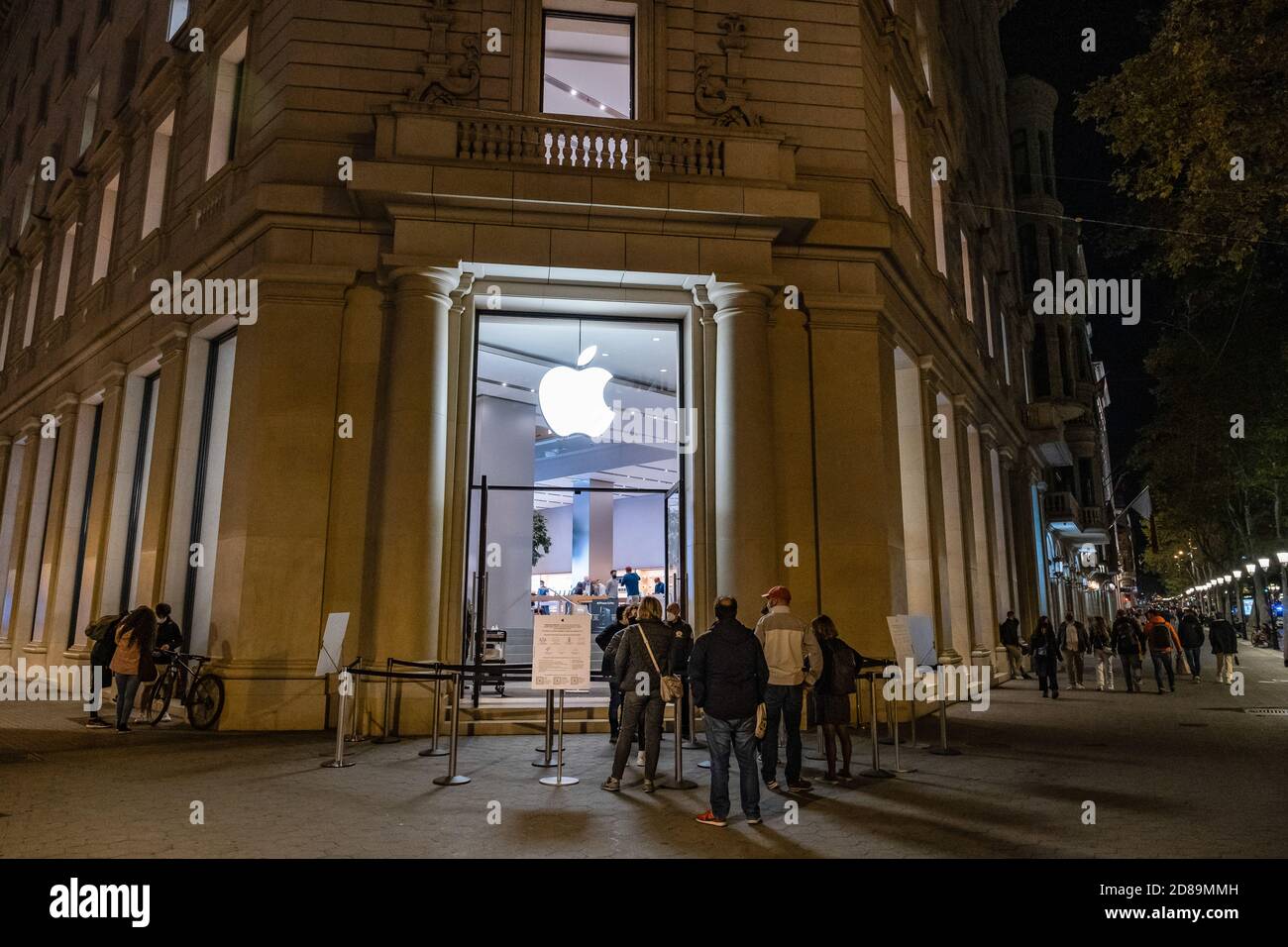 Barcelona, Spain. 27th Oct, 2020. People are seen queuing to enter the Apple store in Plaza Catalunya with less than an hour before curfew. The pandemic situation worsens in Barcelona due to the rising cases of Covid19 infections. Barcelona will have to face new restrictive measures for the mobility of citizens starting this week. The cut in business hours advances the closure at 9:00 p.m. and an hour later the start of curfew for all citizens who do not have a proof of authorized mobility. Credit: SOPA Images Limited/Alamy Live News Stock Photo