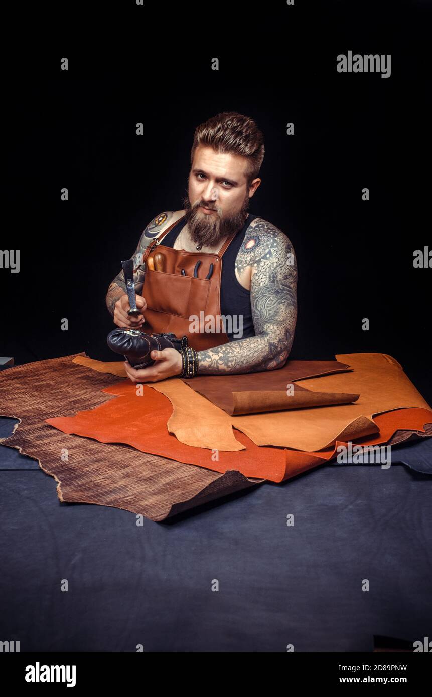 Handyman processing a leather workpiece at the tanning shop Stock Photo