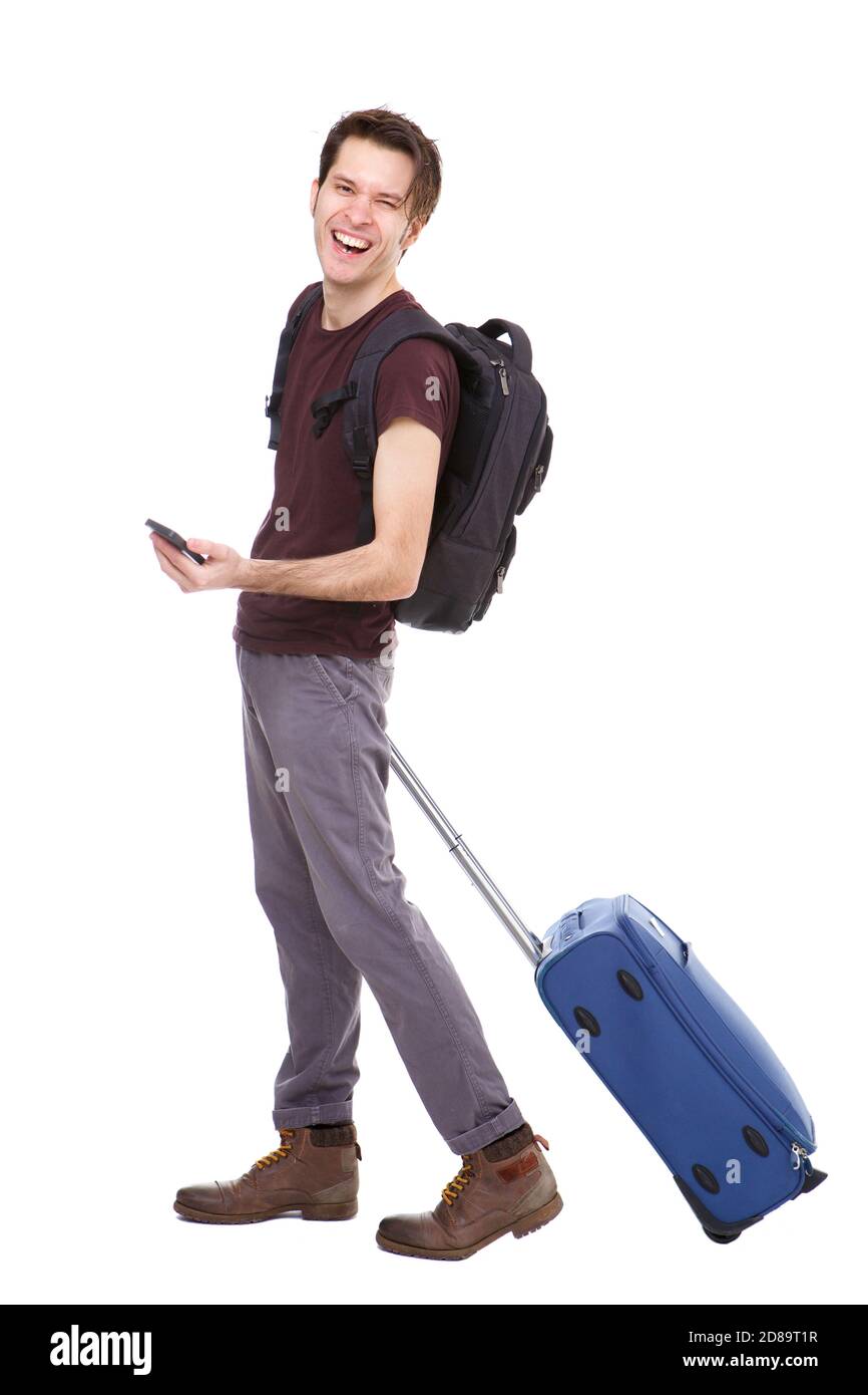 Full length portrait of handsome young man with suitcase and backpack holding phone Stock Photo