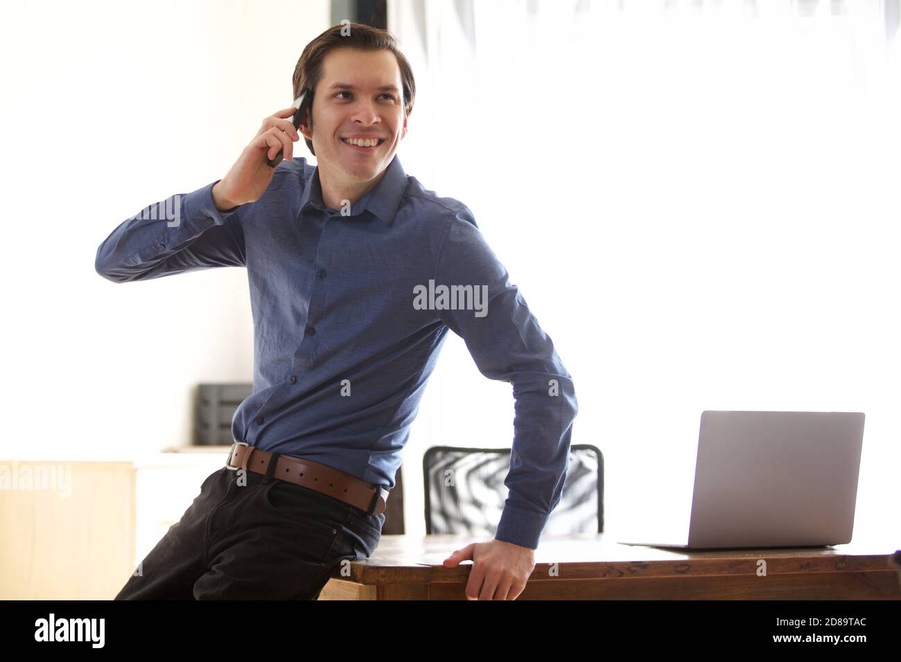 Portrait of happy businessman man on phone call leaning on desk Stock Photo