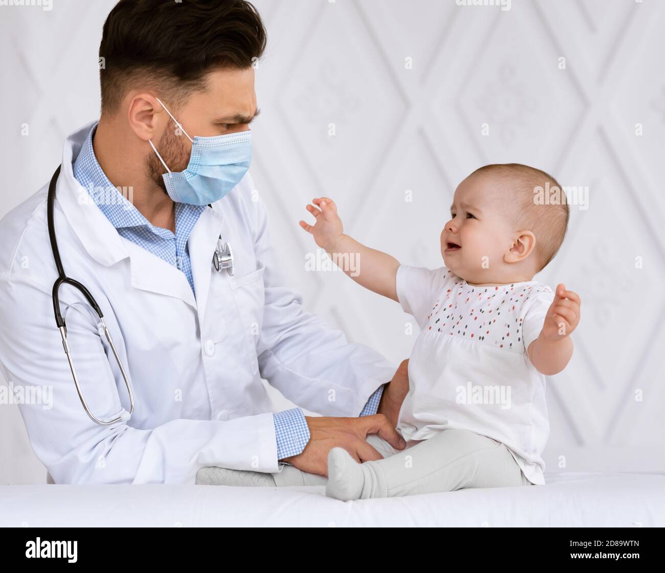 Sick Little Newborn Patient Crying During Medical Checkup In Hospital Stock Photo