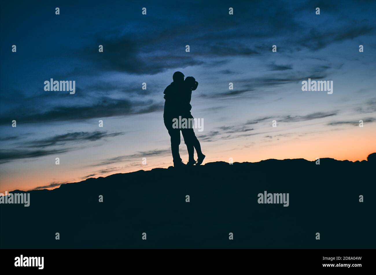 Silhouette of a kissing couple in nature at sunset Stock Photo - Alamy