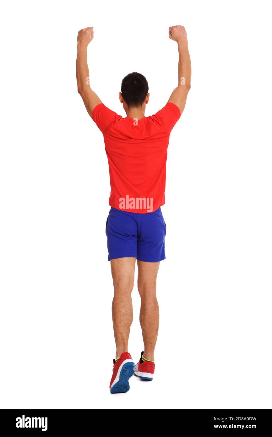 Portrait from behind of a happy man running with arms raised and clenched fist on white