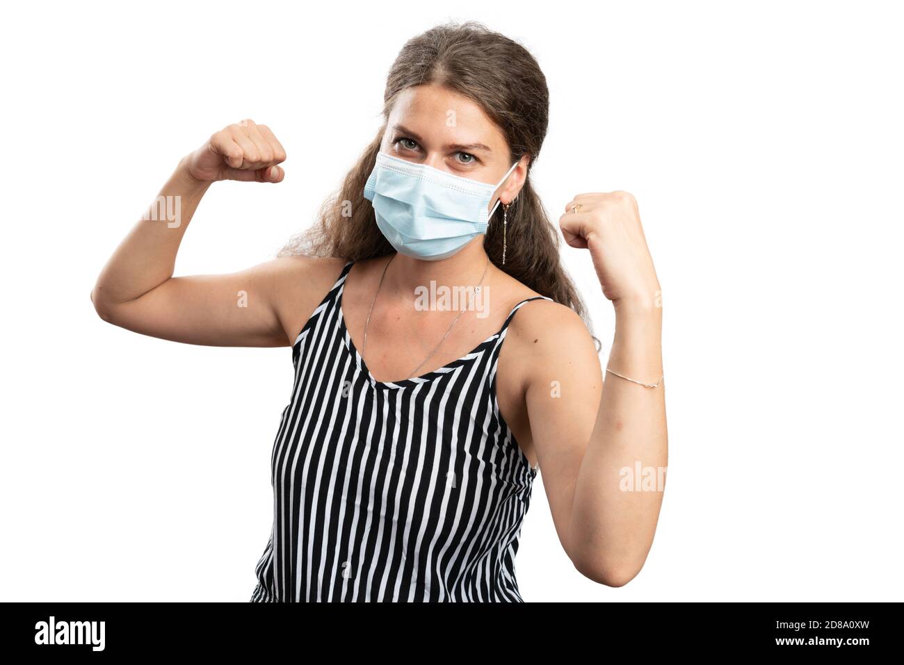 Happy adult woman making celebrating success victory power gesture using hands fists wearing covid19 medical or surgical disposable mask to prevent vi Stock Photo