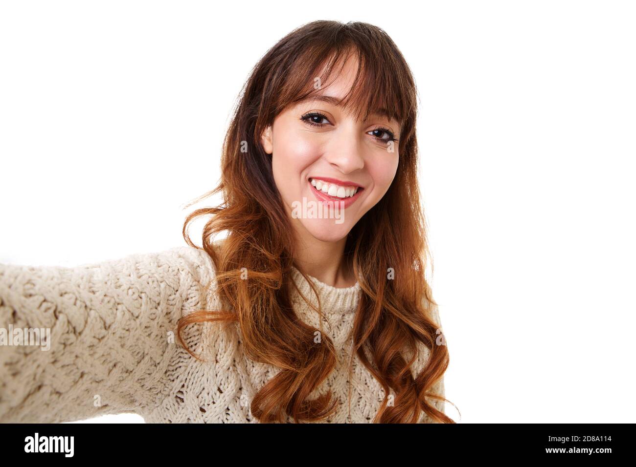 Portrait of young woman smiling and taking a selfie against isolated ...