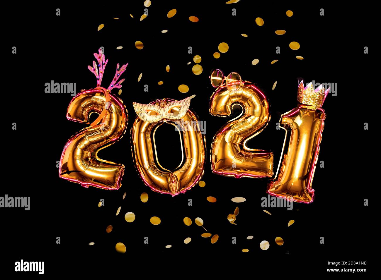 Gold numbers 2021 on black background in carnival accessories, new year party Stock Photo
