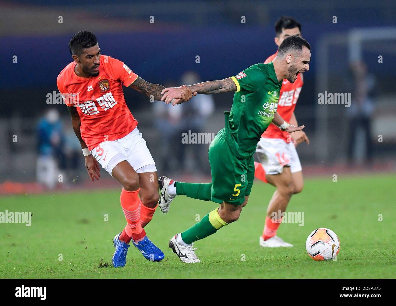 Suzhou, China's Jiangsu Province. 28th Oct, 2020. Renato Augusto (R) of Beijing Guoan is tackled during the 17th round match between Beijing Guoan and Guangzhou Evergrande Taobao at 2020 season Chinese Football Association Super League (CSL) Suzhou Division in Suzhou, east China's Jiangsu Province, Oct. 28, 2020. Credit: Xu Chang/Xinhua/Alamy Live News Stock Photo