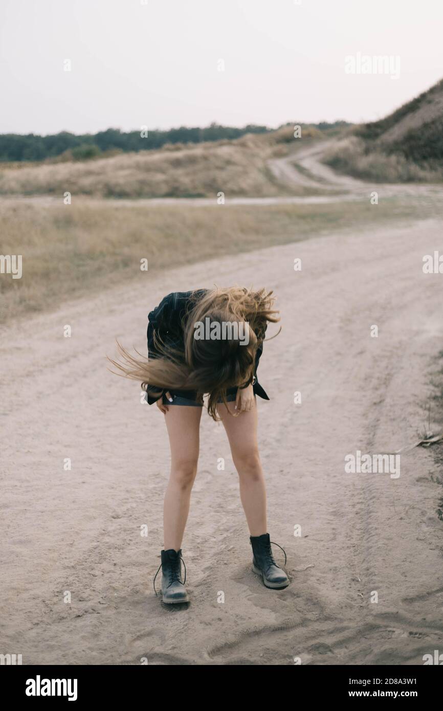 girl shakes her head on a wasteland with sand Stock Photo