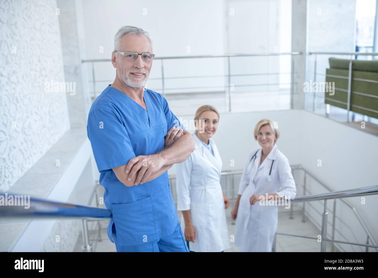 Team of smiling medical workers standing on stairs Stock Photo