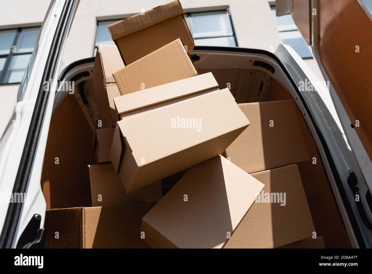 Low angle view of carton boxes in truck with open doors on urban street ...