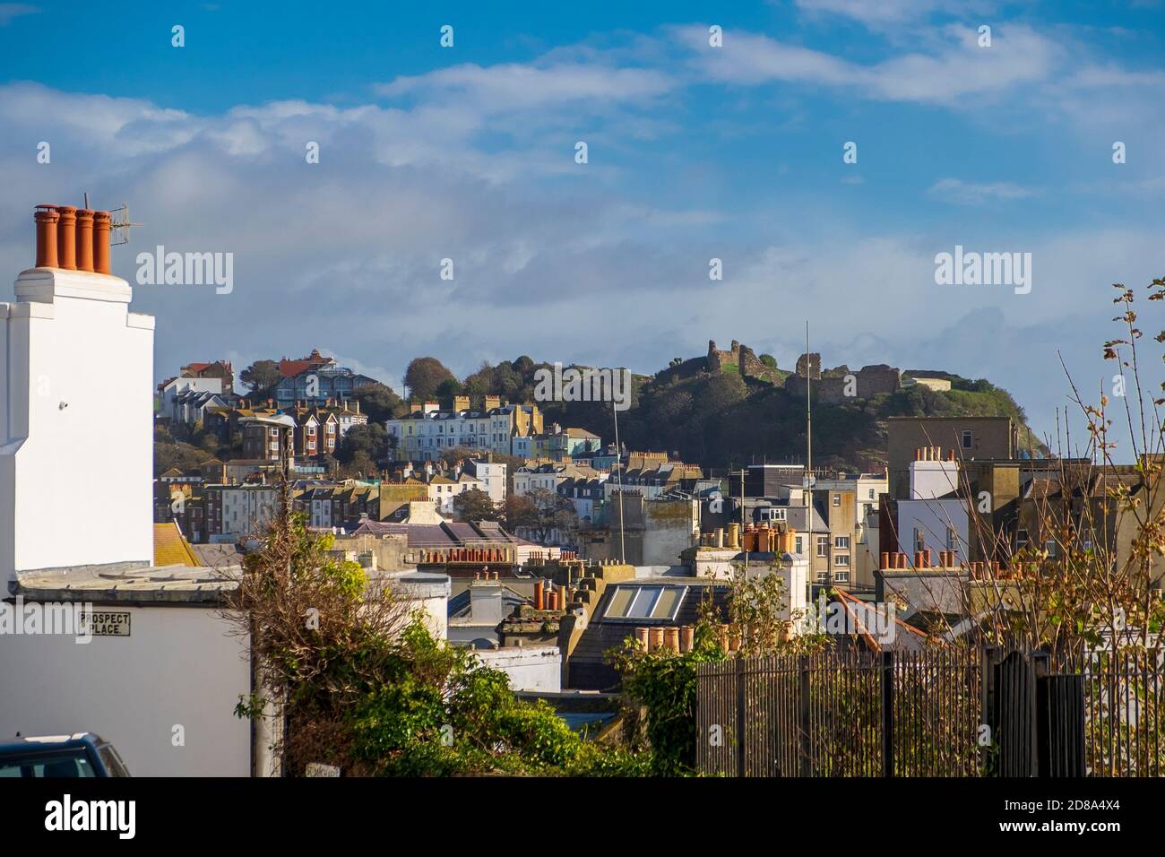 A view across the roof tops of Hastings Town centre towards the ruins of the medieval castle on the West Hill. Stock Photo