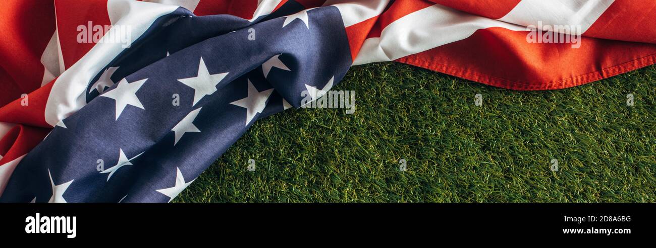 horizontal image of american flag with stars and stripes on green grass outside, labor day concept Stock Photo