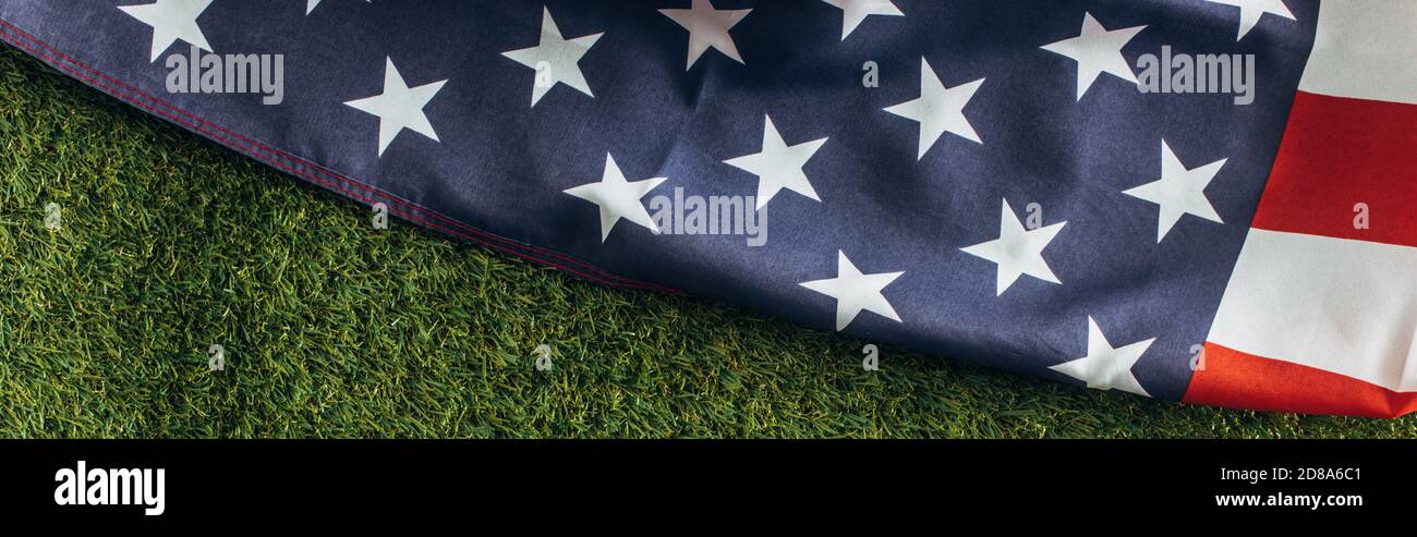 horizontal crop of american flag with stars and stripes on green grass outside, labor day concept Stock Photo