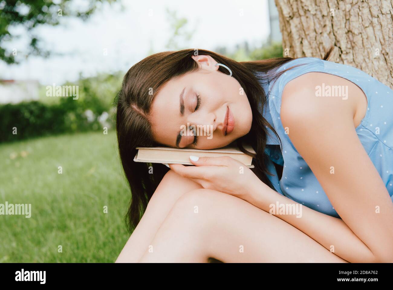 young and beautiful woman with closed eyes holding book Stock Photo - Alamy
