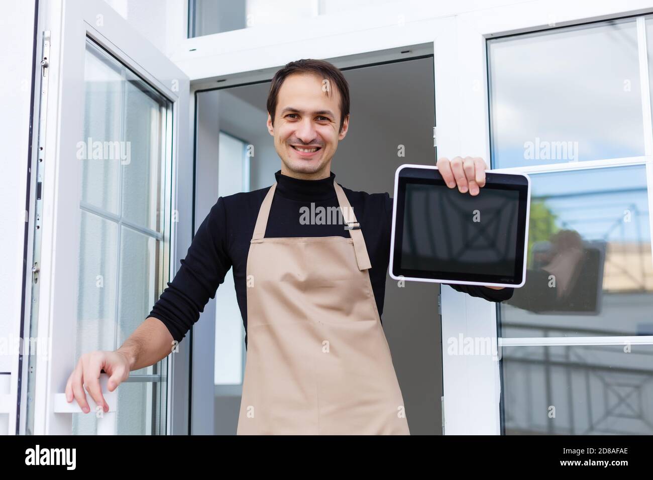 Young male owner using digital tablet while standing in shop Stock Photo